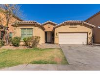 Lovely single-Gathering home with a well-maintained front lawn, a two-car garage, and desert-style landscaping elements at 10004 W Raymond Street St, Tolleson, AZ 85353