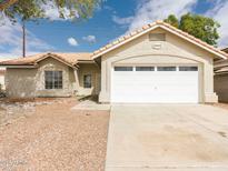 Charming single-story home with a two-car garage and low-maintenance desert landscaping at 1052 W Paseo Way, Tempe, AZ 85283