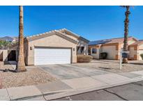 Inviting single-story home with attached garage, desert landscaping, and solar panels on a neighboring roof at 13534 W Young St, Surprise, AZ 85374