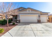 Attractive single-story home featuring a three-car garage, desert landscaping, and stone accents at 141 W Jamaica Pl, Casa Grande, AZ 85122