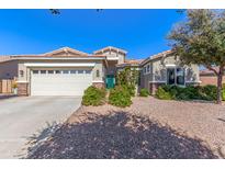 Charming home showcasing a lush landscaped yard, an attached garage, and a decorative front door at 3020 E Tiffany Way, Gilbert, AZ 85298