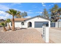 Charming single-story home with desert landscaping, a two-car garage, and palm trees in the front yard at 3906 W Pershing Ave, Phoenix, AZ 85029