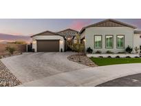 Stunning exterior view of home featuring a brick driveway, desert landscaping and a two-car garage at 4247 E Tonto Pl, Chandler, AZ 85249