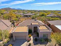 Stunning aerial view of a home with a desert landscape, red tile roof, and attached garage at 7019 E Thirsty Cactus Ln, Scottsdale, AZ 85266