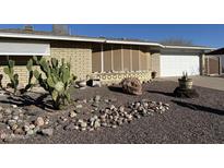 Charming single-story home featuring desert landscaping, complete with cacti and decorative rock features at 715 N 65Th Pl, Mesa, AZ 85205