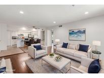 Bright and airy living room featuring hardwood floors, white furniture, and an open floor plan to the kitchen at 7777 E Main St # 258, Scottsdale, AZ 85251