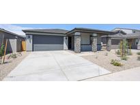 Charming single-story home with a stone-accented porch and a spacious driveway at 17996 W Camino De Oro --, Surprise, AZ 85387
