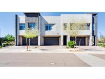 Modern townhome features clean lines, multiple garage spaces, and desert landscaping in a vibrant community at 1940 W Kinfield Trl, Phoenix, AZ 85085