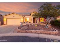 Charming single-story home featuring a two-car garage, desert landscaping, and a cozy front patio at 20151 N Riverbank Rd, Maricopa, AZ 85138