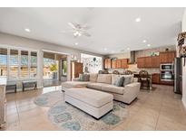 Bright open-concept living room featuring tile flooring, neutral decor, and seamless access to the outdoor patio at 22426 N 29Th Pl, Phoenix, AZ 85050