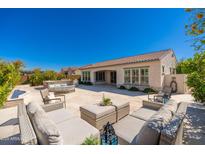 Expansive outdoor living area featuring a large patio, lounge furniture, and a beautiful stone fireplace at 22426 N 29Th Pl, Phoenix, AZ 85050