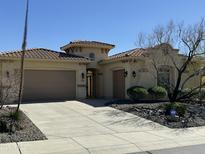 Charming single-story home featuring a tile roof, desert landscaping, and a spacious three-car garage at 31483 N 133Rd Dr, Peoria, AZ 85383