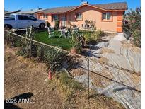 Charming single-story home featuring a well-maintained front yard with seating area and desert landscape at 4654 S 17Th St, Phoenix, AZ 85040