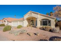 Charming single-story home with desert landscaping, three car garage, and a welcoming front porch entry at 630 W Madero Ave, Mesa, AZ 85210