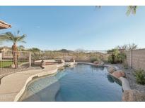 Inviting pool with rock features and desert views, perfect for relaxation and entertaining in the Arizona sun at 7355 W Red Hawk Dr, Peoria, AZ 85383