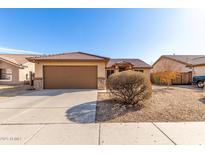 Charming single-story home featuring a two-car garage, desert landscaping, and a terracotta tile roof at 8029 W Whyman Ave, Phoenix, AZ 85043