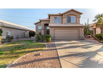 Two-story stucco home showcasing a well-manicured lawn, desert landscaping, and an attached two-car garage at 1119 W Heather Ave, Gilbert, AZ 85233