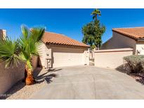 Attached home featuring a two-car garage, tile roof, desert landscaping, private gate, and ample driveway space at 11210 N 109Th St, Scottsdale, AZ 85259