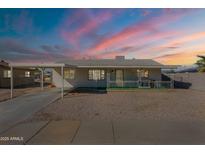 Charming single-story home featuring a front porch, covered parking, and a low-maintenance desert landscape at 12010 N 113Th Ave, Youngtown, AZ 85363