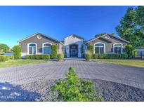 Elegant single-story home with a circular driveway and manicured landscaping at 22406 S 173Rd Way, Gilbert, AZ 85298