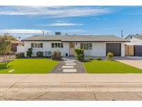 Charming single-story home with manicured lawn, and neutral paint at 7531 E Belleview St, Scottsdale, AZ 85257