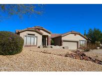 Charming single-story home with desert landscaping and a tile roof under a clear blue sky at 7910 E Snowdon Cir, Mesa, AZ 85207