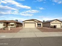 Charming single-story home featuring a well-maintained front yard with desert landscaping and a two-car garage at 8661 N 108Th Ln, Peoria, AZ 85345