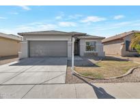 Charming single-story home with a gray exterior, well-manicured yard, and a two-car garage at 9121 W Alvarado St, Phoenix, AZ 85037