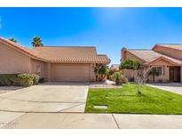 Charming single-story home featuring a well-manicured lawn, mature landscaping, and a two-car garage at 13425 N 92Nd Pl, Scottsdale, AZ 85260