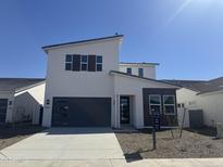 Contemporary two-story home with a sleek design, featuring a modern garage door and neutral color palette at 17957 W Long Lake Rd, Goodyear, AZ 85338