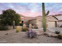 Charming desert home with a landscaped front yard, three car garage, and beautiful sunset sky at 4251 E Desert Forest Trl, Cave Creek, AZ 85331