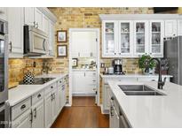 Bright kitchen with white cabinetry, brick backsplash, stainless steel appliances and an open design at 15240 N Clubgate Dr # 160, Scottsdale, AZ 85254