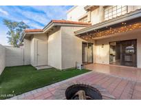 Cozy back patio featuring a fire pit, tiled surface, grassy area, and charming string lights at 1718 S Longmore -- # 41, Mesa, AZ 85202