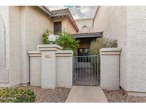 Charming courtyard entrance with secure gate and meticulously maintained stucco facade at 1718 S Longmore -- # 41, Mesa, AZ 85202