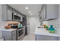 Well-lit kitchen features stainless steel appliances, white countertops, and light gray cabinetry at 3402 N 32Nd St # 118, Phoenix, AZ 85018