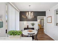 Chic dining area with a chandelier, white table, and dark accent wall creating a stylish ambiance at 5303 N 7Th St # 215, Phoenix, AZ 85014