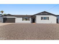 Charming single-story home featuring a well-maintained exterior, black trim, and low maintenance desert landscaping at 7014 E Latham St, Scottsdale, AZ 85257
