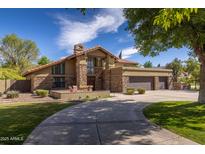 Charming home featuring a stone facade, a circular driveway, and a three-car garage at 8373 S Forest Ave, Tempe, AZ 85284