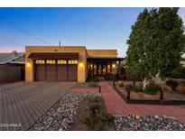 Charming single-story home with a desert landscape, a brick walkway, and a two-car garage at 924 E Whitton Ave, Phoenix, AZ 85014