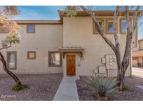 Charming townhouse features a welcoming front door with wreath and desert landscaping at 1225 N 36Th St # 2091, Phoenix, AZ 85008