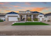 Stunning two-story home with a well-manicured lawn, a three-car garage, and desert landscaping at 17336 W Crawfordsville Dr, Surprise, AZ 85388