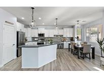 Modern kitchen with white cabinets, stainless steel appliances, and an island with bar seating at 1835 E Bartlett Pl, Chandler, AZ 85249