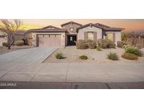 Charming single-story home with desert landscaping, neutral stucco, and a two-car garage at 18406 W Verbena Dr, Goodyear, AZ 85338