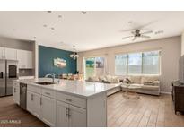 Bright, open kitchen featuring a large island, stainless appliances, and seamless flow to living and dining areas at 1941 W Trotter Trl, Phoenix, AZ 85085
