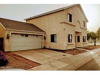 Two-story home featuring an attached garage and a neutral stucco exterior at 2051 W Ronald Rd, Phoenix, AZ 85029