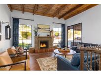 Inviting living room with a stone fireplace, wood beam ceilings, hardwood floors, and comfortable seating at 2548 E Vermont Ave, Phoenix, AZ 85016