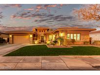 Beautiful single-story home featuring stone accents, a well-manicured lawn, and a warm, inviting ambiance with professional lighting at 3654 E San Pedro Pl, Chandler, AZ 85249