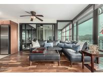 Stylish living room with hardwood floors, sectional sofa, and sliding doors to enclosed patio at 4808 N 24Th St # 1402, Phoenix, AZ 85016