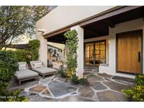 Inviting covered patio with stone flooring, lounge chairs, and an outdoor kitchen area at 5101 N Casa Blanca Dr # 25, Paradise Valley, AZ 85253