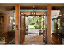 Inviting foyer with wood-framed glass doors leading to a lush backyard and pool at 8022 N Ironwood Dr, Paradise Valley, AZ 85253
